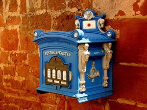 An old blue mailbox mounted on a wall